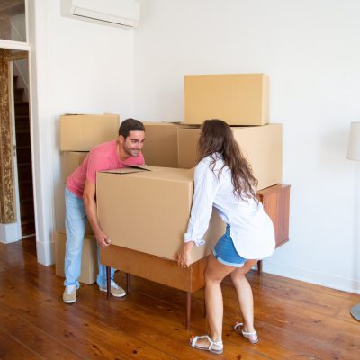 young-family-couple-moving-into-new-apartment-carrying-carton-boxes-furniture_74855-10466